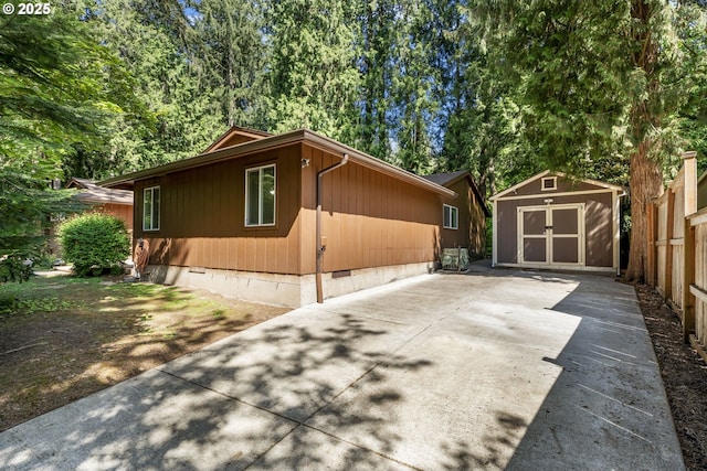 view of property exterior with a storage shed, an outdoor structure, and crawl space