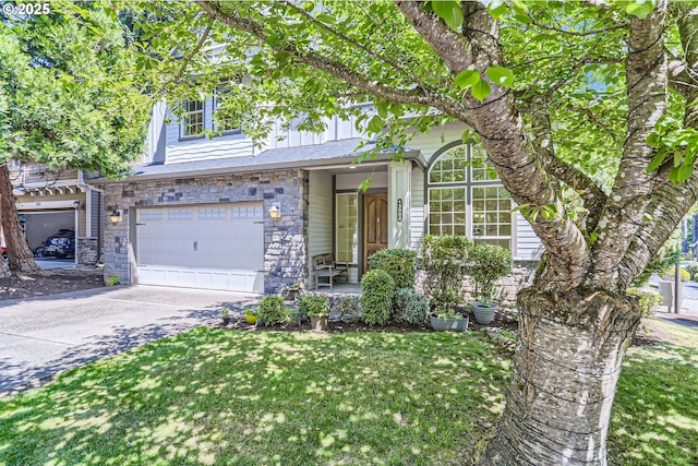 13902 SW Andrew Ter, Portland, OR 97224 - view of front of home with concrete driveway, stone siding, a garage, and a front yard