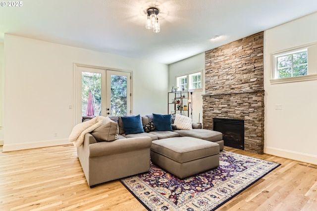 13902 SW Andrew Ter, Portland, OR 97224 - living area featuring healthy amount of natural light, light wood-style floors, french doors, and a fireplace