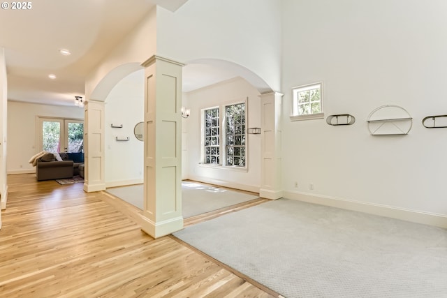 13902 SW Andrew Ter, Portland, OR 97224 - hallway featuring decorative columns, arched walkways, light wood-style floors, and recessed lighting