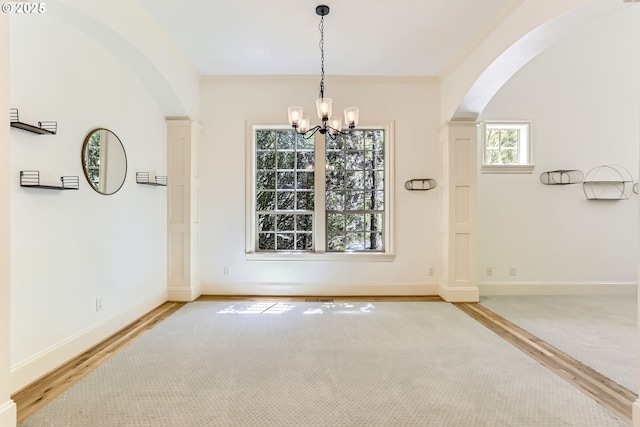 13902 SW Andrew Ter, Portland, OR 97224 - unfurnished dining area featuring arched walkways, a chandelier, light wood-type flooring, and ornamental molding