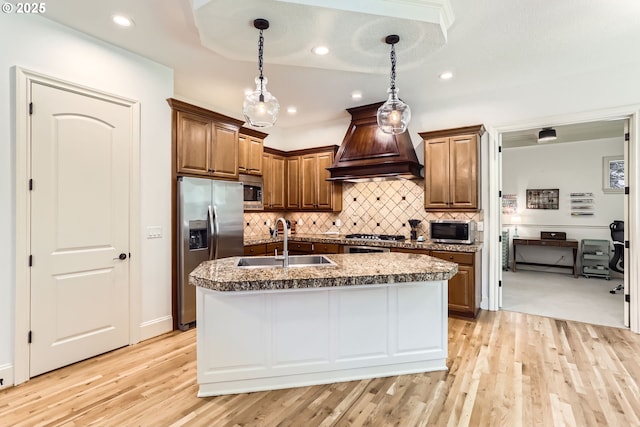 13902 SW Andrew Ter, Portland, OR 97224 - kitchen with appliances with stainless steel finishes, custom range hood, backsplash, light wood finished floors, and pendant lighting