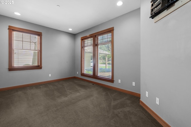 unfurnished room with baseboards, dark colored carpet, visible vents, and recessed lighting