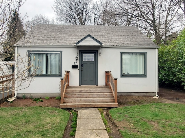 bungalow featuring a shingled roof and stucco siding