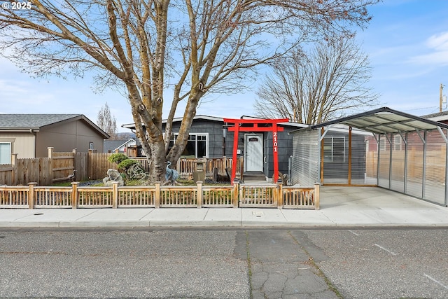 view of front of home with a carport, driveway, and a fenced front yard