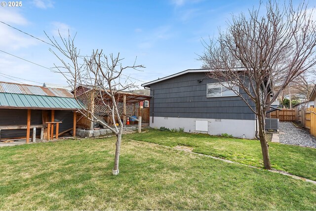 view of yard featuring an outbuilding, central air condition unit, and fence