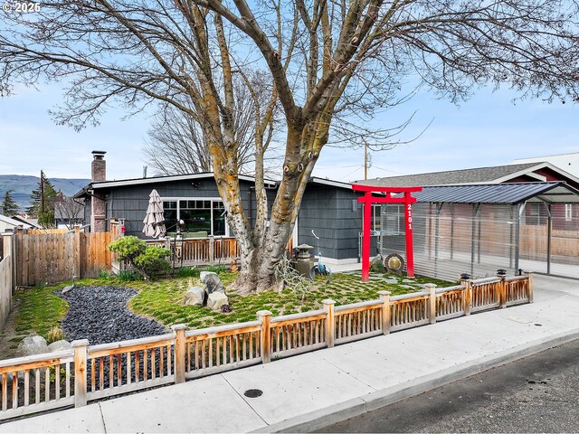 view of front of home with a deck with mountain view and fence