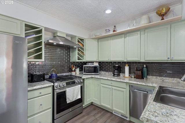 kitchen featuring an ornate ceiling, a sink, stainless steel appliances, wall chimney exhaust hood, and backsplash