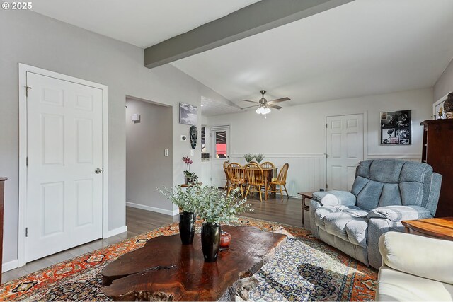 living area with wainscoting, lofted ceiling with beams, ceiling fan, and wood finished floors