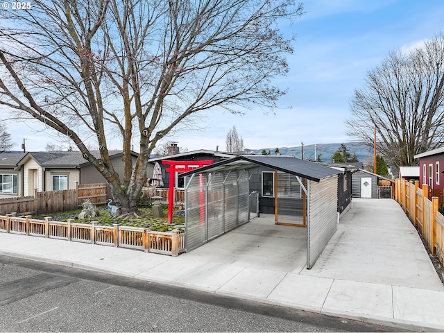 view of front of house featuring an outdoor structure and fence