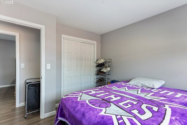 bedroom with a closet, baseboards, and wood finished floors