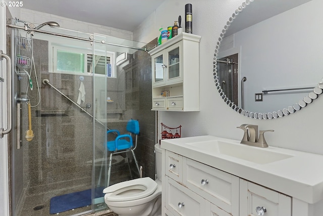 full bathroom featuring vanity, a shower stall, and toilet