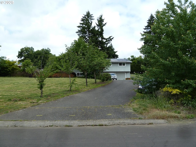 22225 SE Peggy Ann Dr, Damascus, OR 97089 - view of front of home with an attached garage, solar panels, a front yard, and driveway