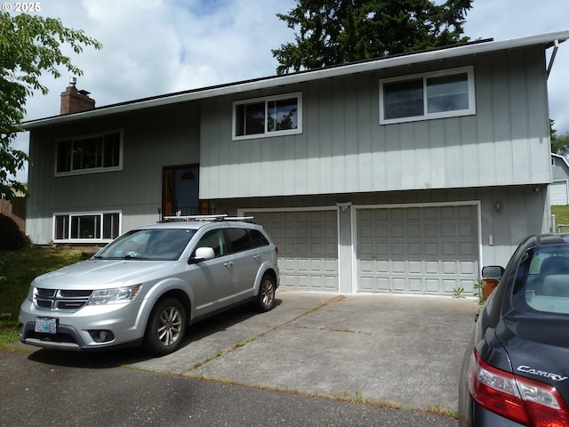 22225 SE Peggy Ann Dr, Damascus, OR 97089 - raised ranch with an attached garage, concrete driveway, and a chimney