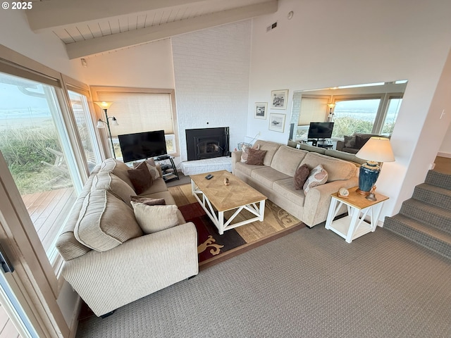 living room featuring high vaulted ceiling, a fireplace, beamed ceiling, and stairway