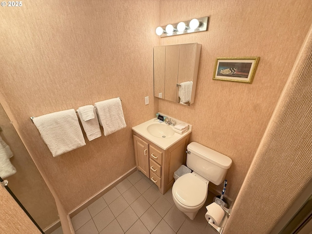 bathroom with toilet, vanity, and tile patterned floors