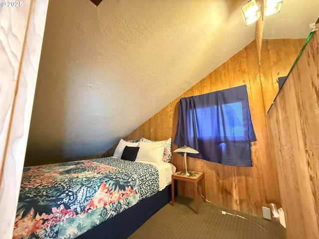 bedroom featuring vaulted ceiling, a textured ceiling, and wooden walls