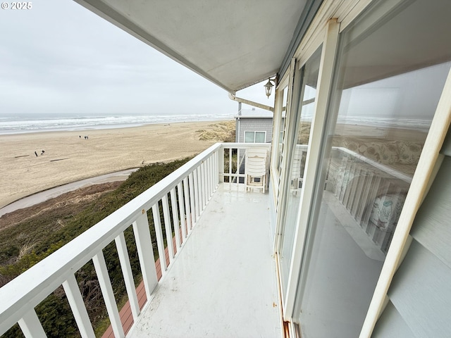 balcony with a beach view and a water view