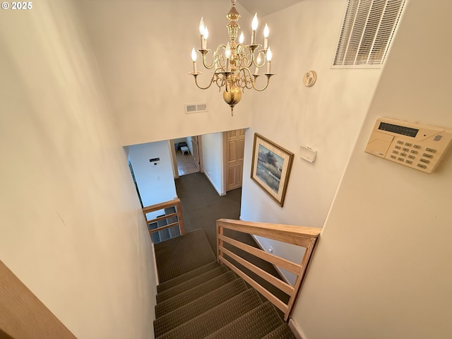 stairs featuring carpet floors, a high ceiling, visible vents, and an inviting chandelier