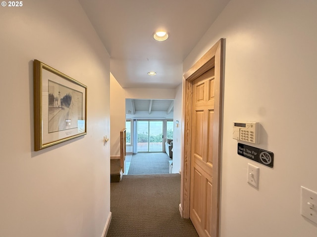 corridor featuring recessed lighting, dark carpet, and baseboards