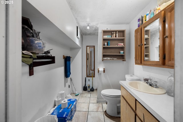 bathroom with vanity, toilet, tile patterned flooring, and a textured ceiling