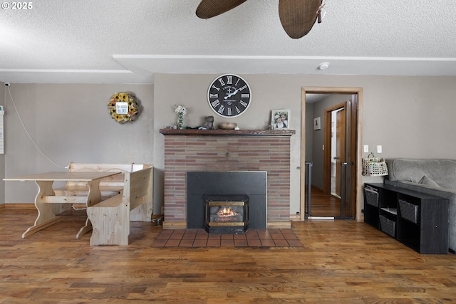 living room featuring ceiling fan, dark hardwood / wood-style flooring, and a textured ceiling