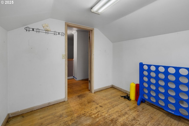 bonus room with wood-type flooring and vaulted ceiling