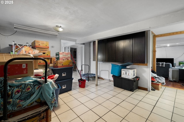 basement with light tile patterned flooring and radiator heating unit