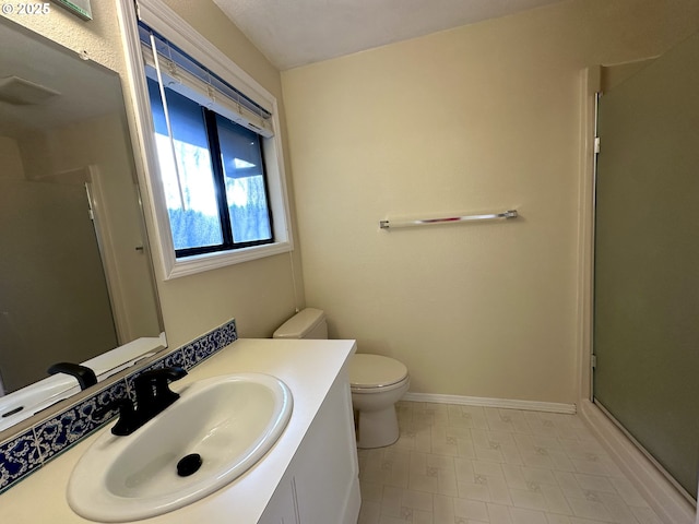 bathroom with vanity, a shower with shower door, and toilet