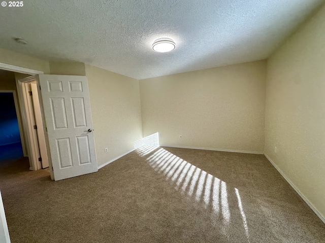 unfurnished room with carpet and a textured ceiling