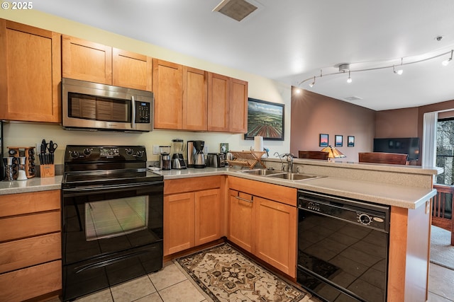 620 NW Naito Pkwy Unit B12, Portland, OR 97209 - kitchen featuring black appliances, a peninsula, a sink, and light countertops