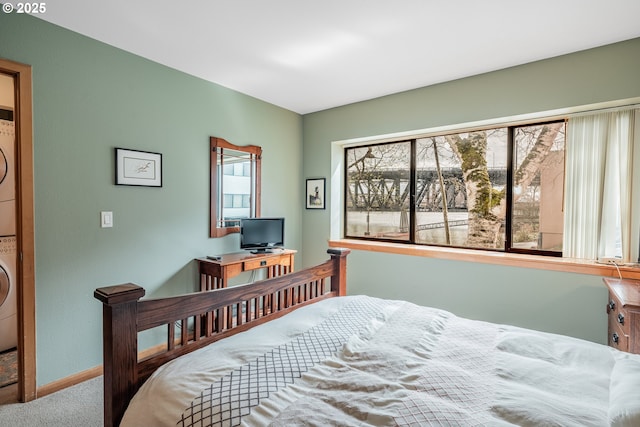 620 NW Naito Pkwy Unit B12, Portland, OR 97209 - carpeted bedroom featuring baseboards and stacked washing maching and dryer