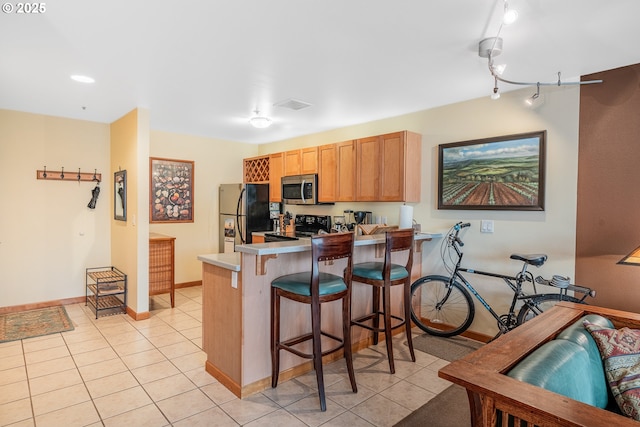 620 NW Naito Pkwy Unit B12, Portland, OR 97209 - kitchen with stainless steel appliances, baseboards, a breakfast bar area, and light tile patterned flooring