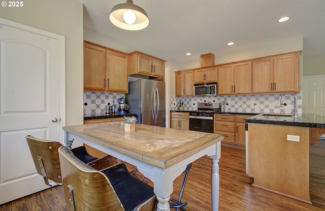 10201 NE 46th Ave, Vancouver, WA 98686 - kitchen featuring appliances with stainless steel finishes, dark wood-type flooring, a breakfast bar, backsplash, and recessed lighting