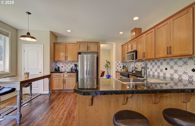 10201 NE 46th Ave, Vancouver, WA 98686 - kitchen featuring stainless steel appliances, a peninsula, dark wood-style flooring, backsplash, and pendant lighting