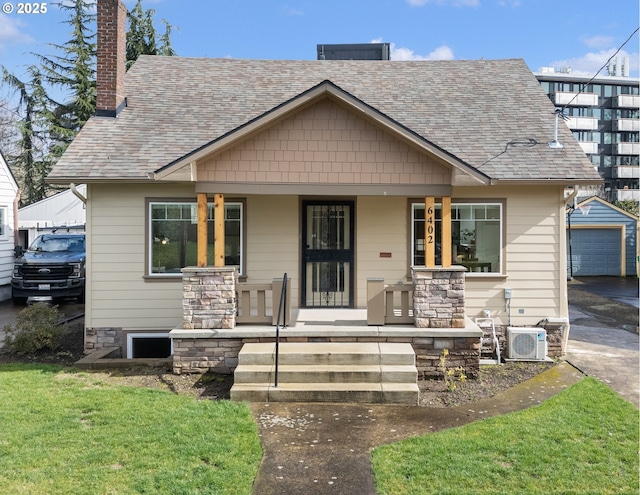 bungalow-style home featuring a chimney, roof with shingles, covered porch, an outdoor structure, and ac unit