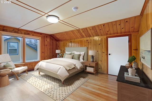 bedroom with wood walls and lofted ceiling
