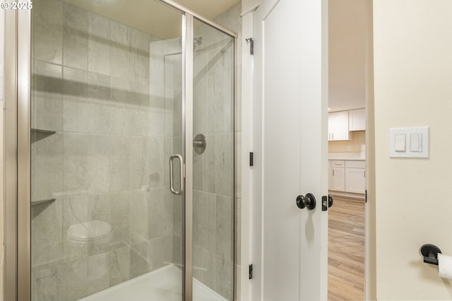 full bath featuring a shower stall, vanity, and wood finished floors