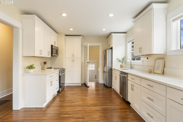 kitchen with dark wood finished floors, white cabinets, recessed lighting, light countertops, and stainless steel appliances