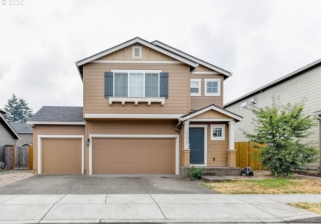 view of front of house featuring fence, driveway, board and batten siding, and a garage