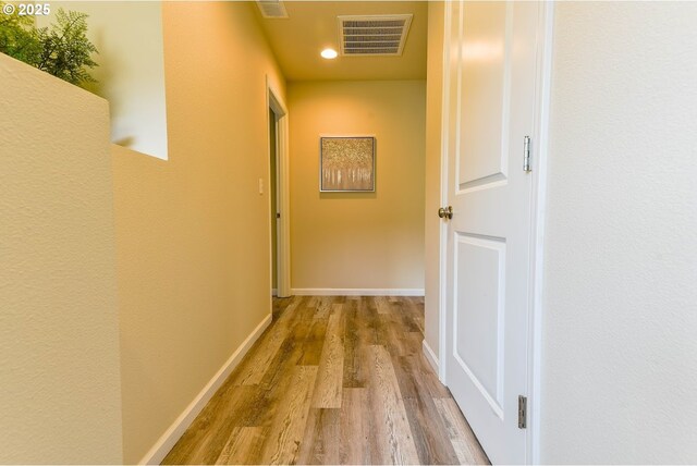 corridor featuring recessed lighting, wood finished floors, visible vents, and baseboards