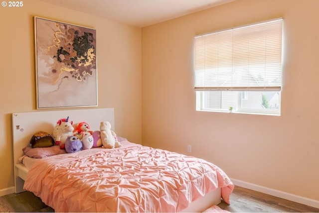 bedroom with wood finished floors and baseboards