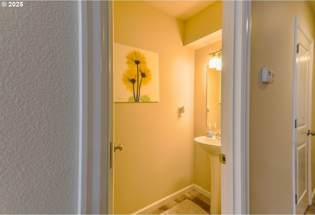 bathroom with baseboards and wood finished floors