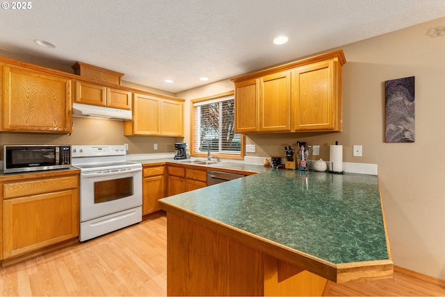 3929 SE 117th Pl, Portland, OR 97266 - kitchen featuring appliances with stainless steel finishes, under cabinet range hood, a peninsula, light wood-type flooring, and recessed lighting