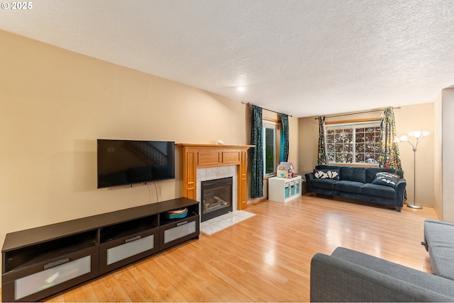 3929 SE 117th Pl, Portland, OR 97266 - living room with light wood-type flooring, a textured ceiling, and a tile fireplace