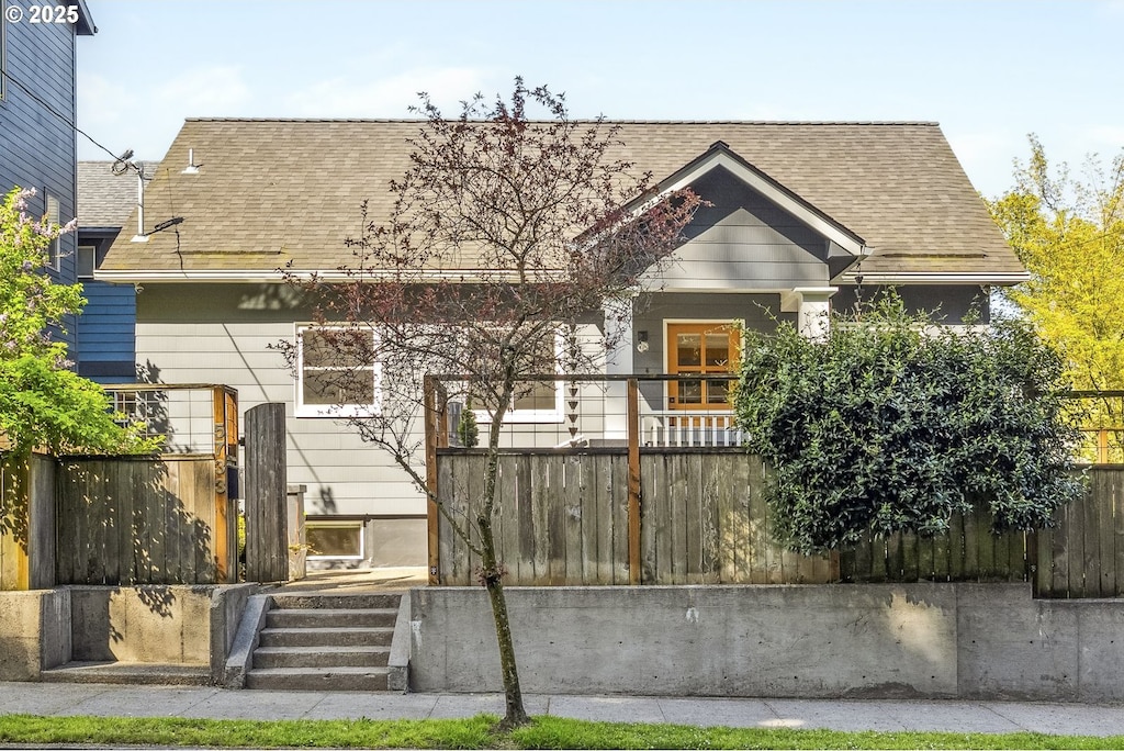 view of front of house featuring fence and roof with shingles