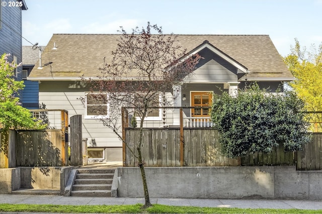 view of front of house featuring fence and roof with shingles