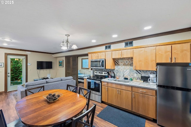 1230 Seagate Ave, Coos Bay, OR 97420 - kitchen featuring stainless steel appliances, a sink, a chandelier, tasteful backsplash, and light wood-type flooring