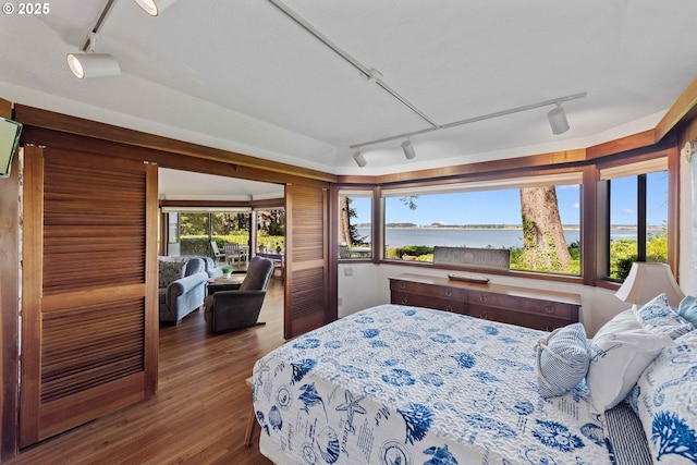 1230 Seagate Ave, Coos Bay, OR 97420 - bedroom with rail lighting, wood finished floors, and a water view