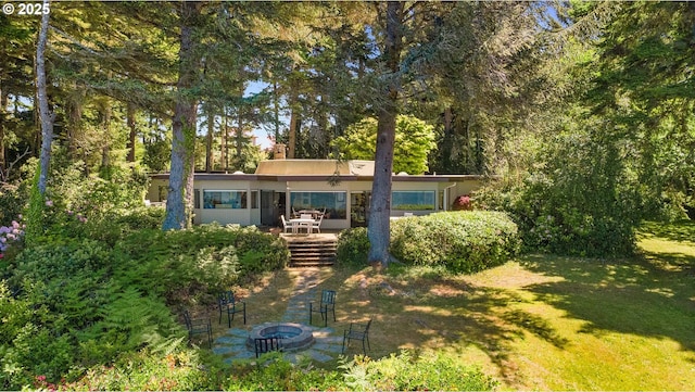 1230 Seagate Ave, Coos Bay, OR 97420 - back of house with an outdoor fire pit, a yard, a wooden deck, and stucco siding